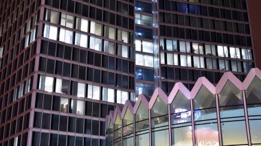 Office building at night, building facade with glass and lights. View with illuminated modern skyscraper.