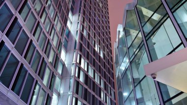 Office building at night, building facade with glass and lights. View with illuminated modern skyscraper.