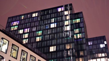 Office building at night, building facade with glass and lights. View with illuminated modern skyscraper.
