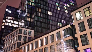 Office building at night, building facade with glass and lights. View with illuminated modern skyscraper.