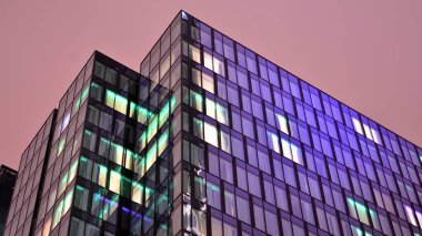 Office building at night, building facade with glass and lights. View with illuminated modern skyscraper.
