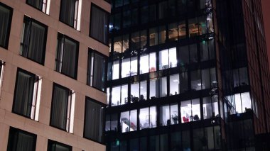 Geceleri ofis binası, cam ve ışıklarla bina cephesi. Aydınlatılmış modern gökdelen ile görüntüle.
