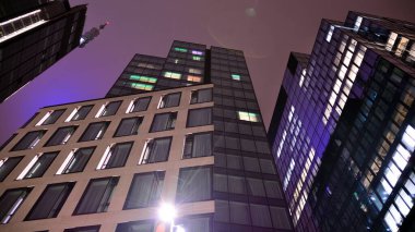 Office building at night, building facade with glass and lights. View with illuminated modern skyscraper.