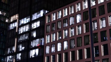 Geceleri ofis binası, cam ve ışıklarla bina cephesi. Aydınlatılmış modern gökdelen ile görüntüle.