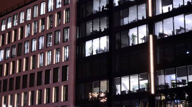 Geceleri ofis binası, cam ve ışıklarla bina cephesi. Aydınlatılmış modern gökdelen ile görüntüle.