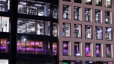 Office building at night, building facade with glass and lights. View with illuminated modern skyscraper.