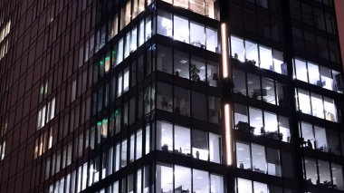 Geceleri ofis binası, cam ve ışıklarla bina cephesi. Aydınlatılmış modern gökdelen ile görüntüle.