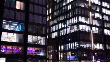 Office building at night, building facade with glass and lights. View with illuminated modern skyscraper.