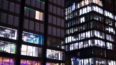 Office building at night, building facade with glass and lights. View with illuminated modern skyscraper.
