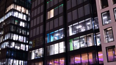 Geceleri ofis binası, cam ve ışıklarla bina cephesi. Aydınlatılmış modern gökdelen ile görüntüle.
