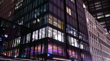 Office building at night, building facade with glass and lights. View with illuminated modern skyscraper.