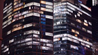 Office building at night, building facade with glass and lights. View with illuminated modern skyscraper.