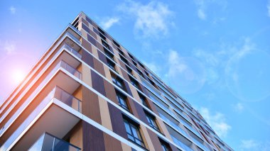 Mavi gökyüzüne karşı birçok penceresi olan ön bina.