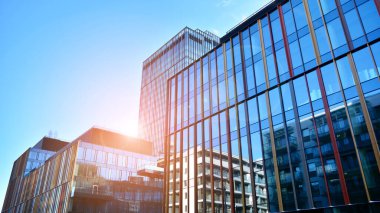 Soyut ve karmaşık mavi gökdelen yapısı şehir merkezinde gökyüzü ve kırmızı güneş arka planda