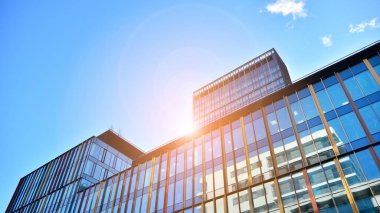 Soyut ve karmaşık mavi gökdelen yapısı şehir merkezinde gökyüzü ve kırmızı güneş arka planda