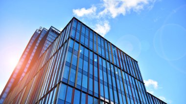 Soyut ve karmaşık mavi gökdelen yapısı şehir merkezinde gökyüzü ve kırmızı güneş arka planda