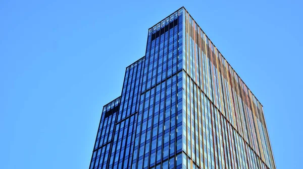 ブルーガラス窓付きのモダンなオフィスビルでご覧ください 背景に空を背景にした抽象的で複雑な青の超高層ビル構造 — ストック写真