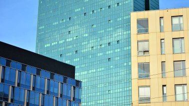 Yeni modern ofis binasının yanında camdan yüzlü modern bir apartman manzarası..