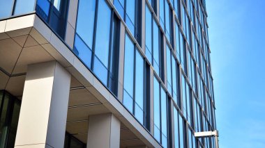 Güneşli bir günde gökyüzünün yansımasıyla modern cam şirket mimarisi