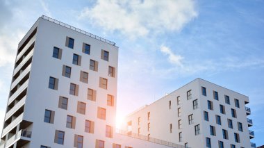 Modern lüks konut dairesi. Güneşli bir günde modern apartman binası. Mavi gökyüzü olan beyaz bir apartman. Modern bir apartmanın cephesi.