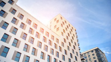 Modern lüks konut dairesi. Güneşli bir günde modern apartman binası. Mavi gökyüzü olan beyaz bir apartman. Modern bir apartmanın cephesi.