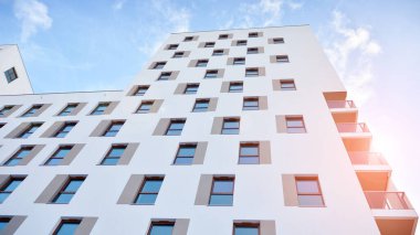 Modern lüks konut dairesi. Güneşli bir günde modern apartman binası. Mavi gökyüzü olan beyaz bir apartman. Modern bir apartmanın cephesi.