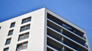 Modern lüks konut dairesi. Güneşli bir günde modern apartman binası. Mavi gökyüzü olan beyaz bir apartman. Modern bir apartmanın cephesi.