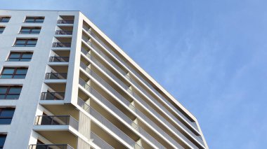 Modern lüks konut dairesi. Güneşli bir günde modern apartman binası. Mavi gökyüzü olan beyaz bir apartman. Modern bir apartmanın cephesi.