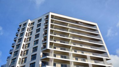 Modern lüks konut dairesi. Güneşli bir günde modern apartman binası. Mavi gökyüzü olan beyaz bir apartman. Modern bir apartmanın cephesi.