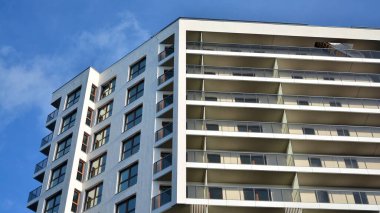 Modern lüks konut dairesi. Güneşli bir günde modern apartman binası. Mavi gökyüzü olan beyaz bir apartman. Modern bir apartmanın cephesi.