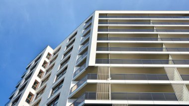 Modern lüks konut dairesi. Güneşli bir günde modern apartman binası. Mavi gökyüzü olan beyaz bir apartman. Modern bir apartmanın cephesi.