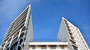 Modern lüks konut dairesi. Güneşli bir günde modern apartman binası. Mavi gökyüzü olan beyaz bir apartman. Modern bir apartmanın cephesi.