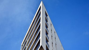 Modern lüks konut dairesi. Güneşli bir günde modern apartman binası. Mavi gökyüzü olan beyaz bir apartman. Modern bir apartmanın cephesi.