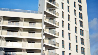 Modern lüks konut dairesi. Güneşli bir günde modern apartman binası. Mavi gökyüzü olan beyaz bir apartman. Modern bir apartmanın cephesi.