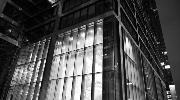 素晴らしい夜の街並み 夜のオフィスビル ガラスと照明付きの建物のファサード 照明付きのモダンな超高層ビルを眺めます 夜の高層ビルの風景輝く窓 黒と白 — ストック写真