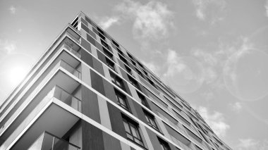 Modern lüks konut dairesi. Güneşli bir günde modern apartman binası. Mavi gökyüzü olan beyaz bir apartman. Modern bir apartmanın ön cephesi. Siyah ve beyaz.