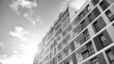 Modern lüks konut dairesi. Güneşli bir günde modern apartman binası. Mavi gökyüzü olan beyaz bir apartman. Modern bir apartmanın ön cephesi. Siyah ve beyaz.