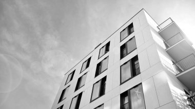 Modern lüks konut dairesi. Güneşli bir günde modern apartman binası. Mavi gökyüzü olan beyaz bir apartman. Modern bir apartmanın ön cephesi. Siyah ve beyaz.