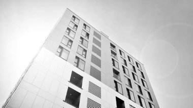 Modern lüks konut dairesi. Güneşli bir günde modern apartman binası. Mavi gökyüzü olan beyaz bir apartman. Modern bir apartmanın ön cephesi. Siyah ve beyaz.