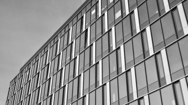 Modern cam ve alüminyum ofis duvarı açık havada güneş ışınları düşüyor. Siyah ve beyaz.