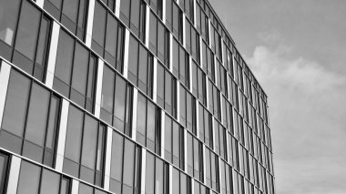 Modern cam ve alüminyum ofis duvarı açık havada güneş ışınları düşüyor. Siyah ve beyaz.