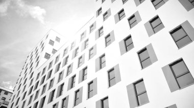 Modern lüks konut dairesi. Güneşli bir günde modern apartman binası. Mavi gökyüzü olan beyaz bir apartman. Modern bir apartmanın ön cephesi. Siyah ve beyaz.