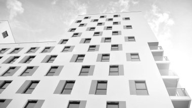 Modern lüks konut dairesi. Güneşli bir günde modern apartman binası. Mavi gökyüzü olan beyaz bir apartman. Modern bir apartmanın ön cephesi. Siyah ve beyaz.