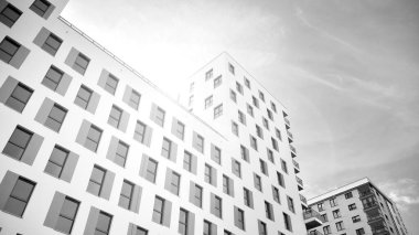 Modern lüks konut dairesi. Güneşli bir günde modern apartman binası. Mavi gökyüzü olan beyaz bir apartman. Modern bir apartmanın ön cephesi. Siyah ve beyaz.