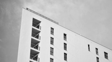 Modern lüks konut dairesi. Güneşli bir günde modern apartman binası. Mavi gökyüzü olan beyaz bir apartman. Modern bir apartmanın ön cephesi. Siyah ve beyaz.