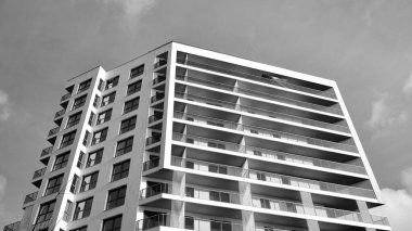 Modern lüks konut dairesi. Güneşli bir günde modern apartman binası. Mavi gökyüzü olan beyaz bir apartman. Modern bir apartmanın ön cephesi. Siyah ve beyaz.