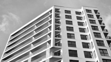 Modern lüks konut dairesi. Güneşli bir günde modern apartman binası. Mavi gökyüzü olan beyaz bir apartman. Modern bir apartmanın ön cephesi. Siyah ve beyaz.