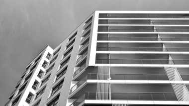 Modern lüks konut dairesi. Güneşli bir günde modern apartman binası. Mavi gökyüzü olan beyaz bir apartman. Modern bir apartmanın ön cephesi. Siyah ve beyaz.