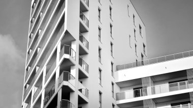 Modern lüks konut dairesi. Güneşli bir günde modern apartman binası. Mavi gökyüzü olan beyaz bir apartman. Modern bir apartmanın ön cephesi. Siyah ve beyaz.