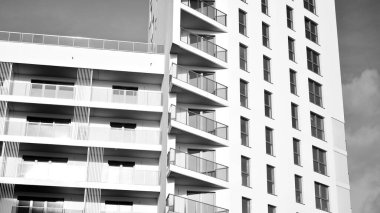 Modern lüks konut dairesi. Güneşli bir günde modern apartman binası. Mavi gökyüzü olan beyaz bir apartman. Modern bir apartmanın ön cephesi. Siyah ve beyaz.